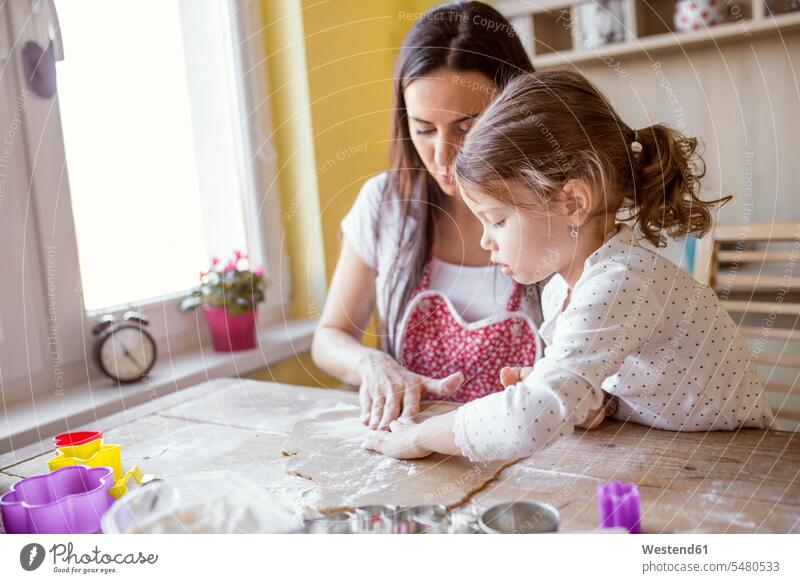 Mutter und kleine Tochter backen zusammen Europäer Kaukasier Europäisch kaukasisch Freizeitkleidung casual Freizeitbekleidung Zusammengehörigkeit Verbundenheit