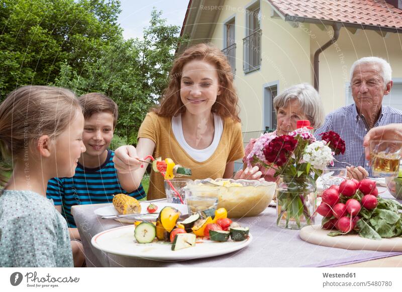 Erweiterte Familiengastronomie im Garten glücklich Glück glücklich sein glücklichsein essen essend Generationen Gärten Gaerten Mensch Menschen Leute People