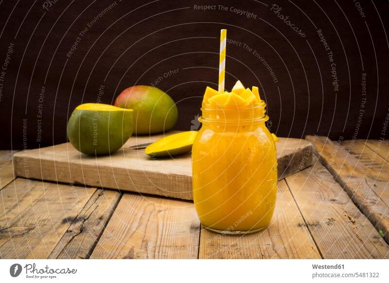 Glas Mango-Smoothie mit Mango-Würfeln garniert Food and Drink Lebensmittel Essen und Trinken Nahrungsmittel Holzbrett Holzplatten Holzbretter hölzern Gläser