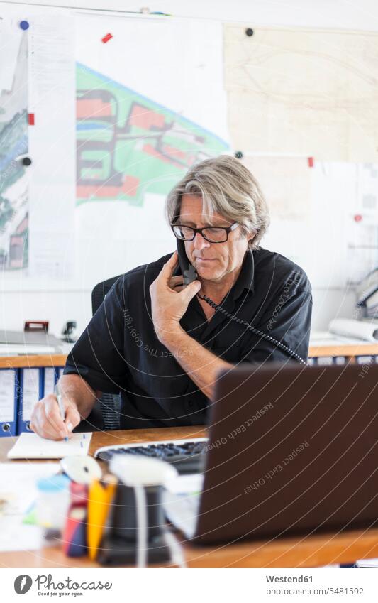 Reifer Mann telefoniert am Schreibtisch in seinem Büro telefonieren anrufen Anruf telephonieren Geschäftsmann Businessmann Businessmänner Geschäftsmänner