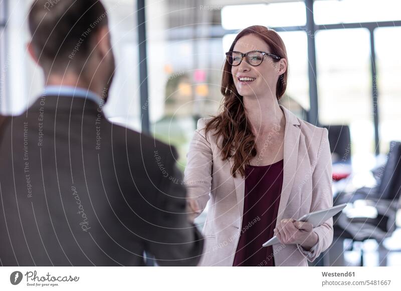 Geschäftsleute schütteln sich im Büro die Hand Tablet Tablet Computer Tablet-PC Tablet PC iPad Tablet-Computer Geschäftspersonen Hände schütteln Handshake