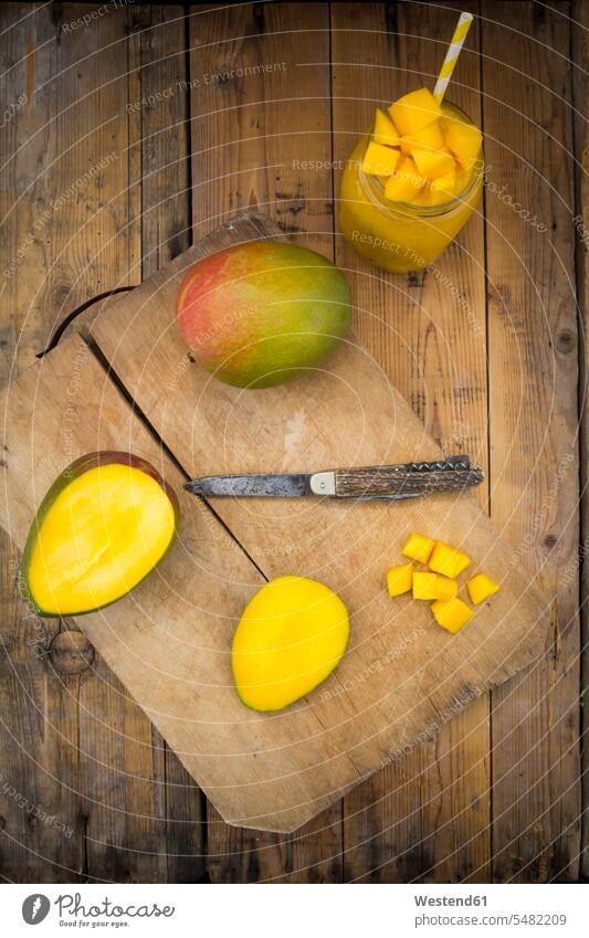 Glas Mango-Smoothie und Mango, ganz und in Scheiben geschnitten Food and Drink Lebensmittel Essen und Trinken Nahrungsmittel Mangos aufgeschnitten angeschnitten