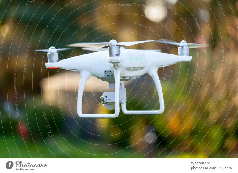 Fliegende Drohne mit Kamera Bewegung sich bewegen Kameras Drohnen Außenaufnahme draußen im Freien weiß weißes weißer weiss unterwegs auf Achse in Bewegung