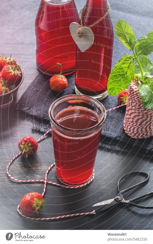 Glas- und Glasflaschen mit hausgemachter Erdbeer-Limonade hölzern süß Süßes zubereitet Frucht Früchte Fruechte servierfertig angerichtet selbstgemacht