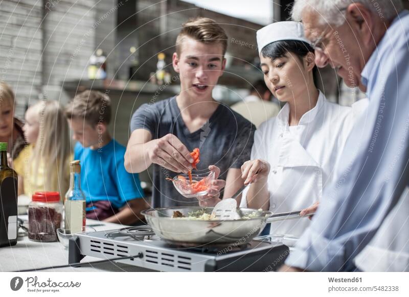 Köchin und Studenten kochen im Kochkurs Küche Gruppe Mensch Gastronomie Zubereitung Teilnehmer Wissen Gesunde Ernährung Sachverstand Zutaten Unterricht