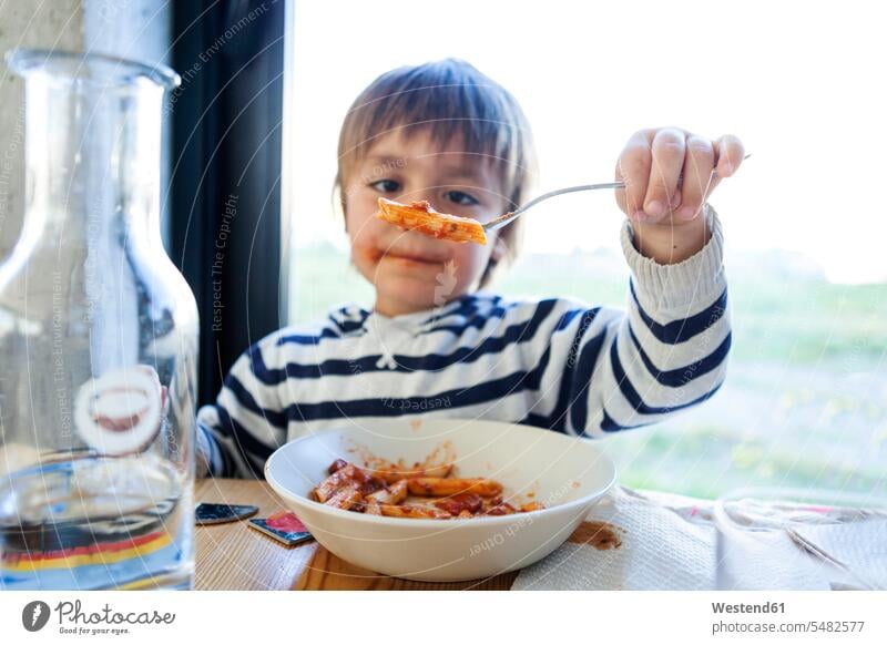 Junge isst Nudeln mit Tomatensauce Europäer Kaukasier Europäisch kaukasisch Restaurant Lokal Speiserestaurant Lokale Speiselokale Restaurants Speiserestaurants