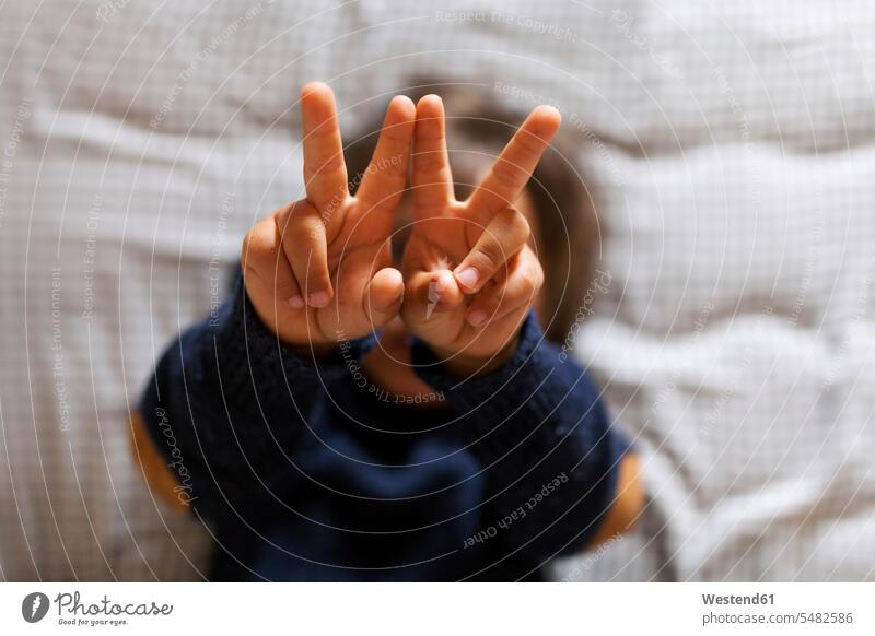 Kleiner Junge macht Siegeszeichen mit seinen Händen Buben Knabe Jungen Knaben männlich Handzeichen Zeichen Kind Kinder Kids Mensch Menschen Leute People