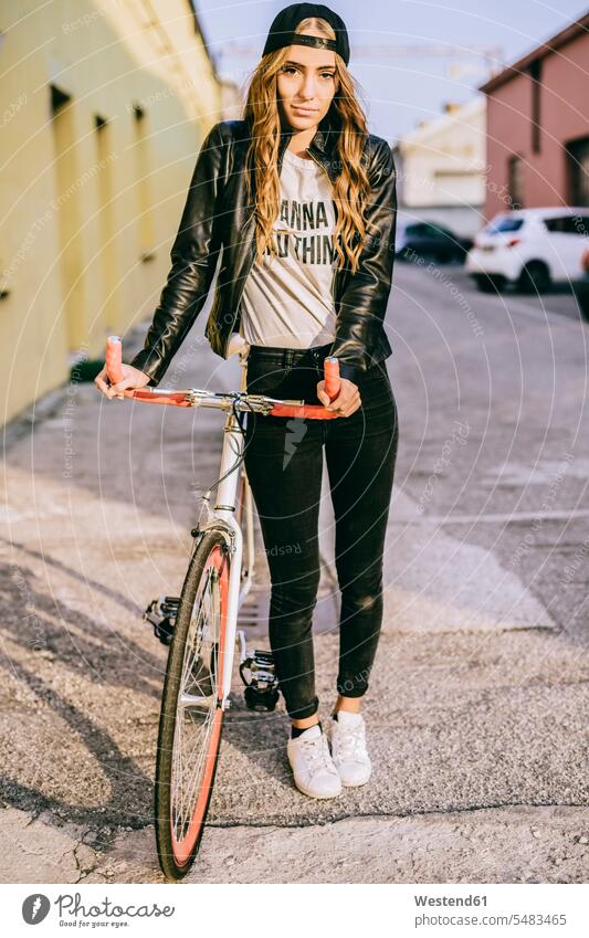 Porträt einer modischen jungen Frau mit Fahrrad Bikes Fahrräder Räder Rad Portrait Porträts Portraits weiblich Frauen Raeder Erwachsener erwachsen Mensch