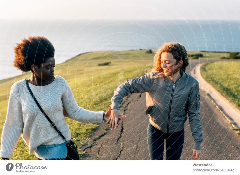 Zwei Beste Freunde Halten Sich Beim Spaziergang An Der Küste An Den Händen Ein Lizenzfreies 
