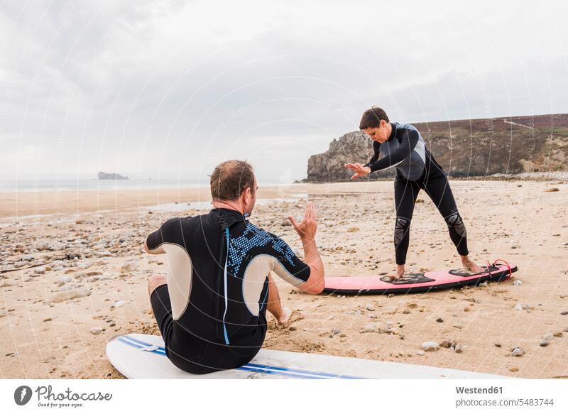 Frankreich, Bretagne, Halbinsel Crozon, Mann unterrichtet Frau Surfen am Strand Surfbrett Surfbretter surfboard surfboards Beach Straende Strände Beaches lernen