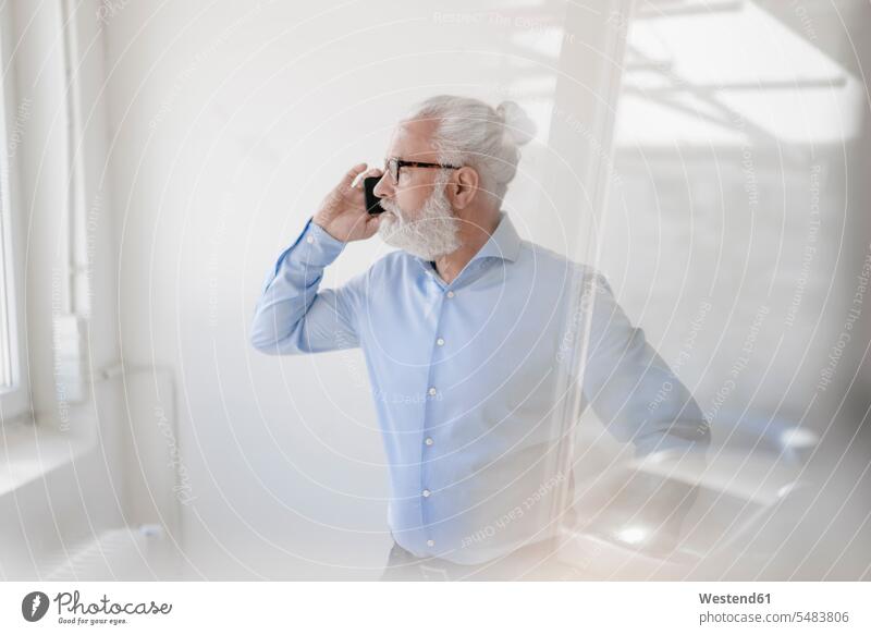 Reifer Mann mit Bart und Brille am Handy telefonieren anrufen Anruf telephonieren Männer männlich Mobiltelefon Handies Handys Mobiltelefone Telefon benutzen