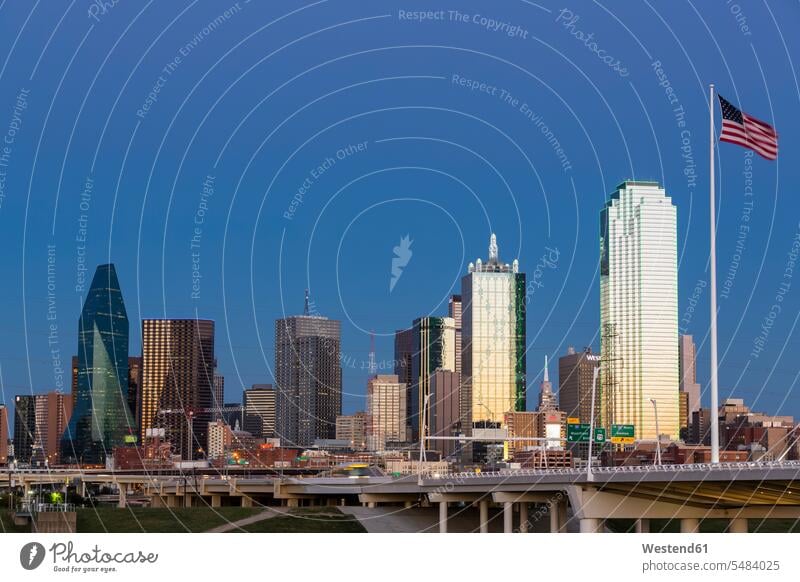 USA, Texas, Skyline von Dallas zur blauen Stunde Stadtlandschaft Stadtansicht Gebäude Flagge Fahnen Flaggen Außenaufnahme draußen im Freien Trinity River