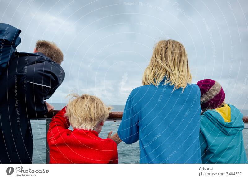Vater mit drei Kindern schaut über die Reling einer Fähre auf die blaugraue Ostsee Familien Schiff Boot Schifffahrt Wasser Meer Wasserfahrzeug maritim