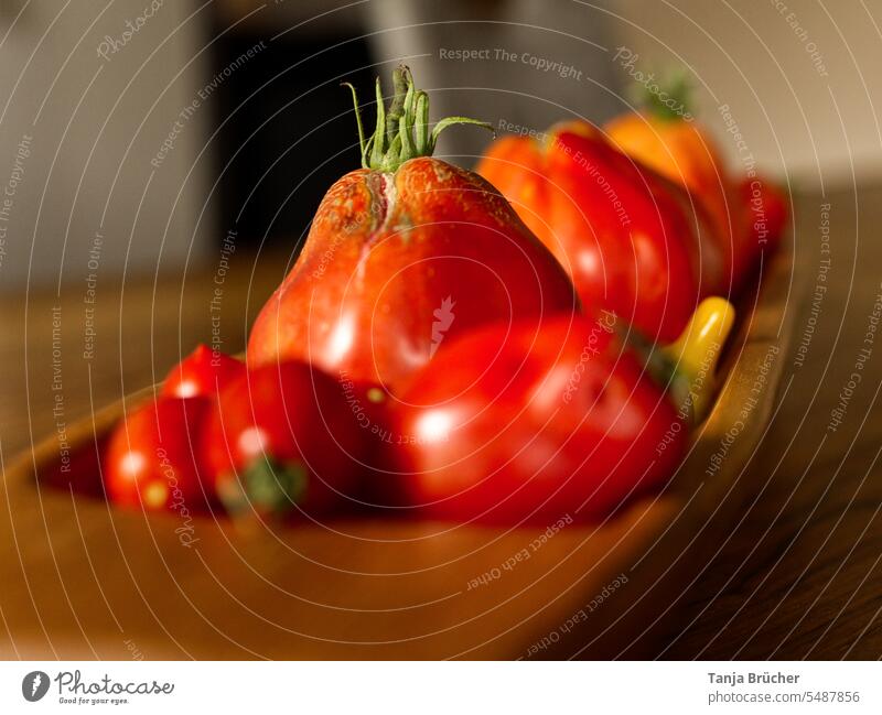 Nahaufnahme Tomaten in einer länglichen Holzschale Bio-Gemüse rote Tomaten gelbe Tomaten Vegane Ernährung frische Ernte viele Tomaten