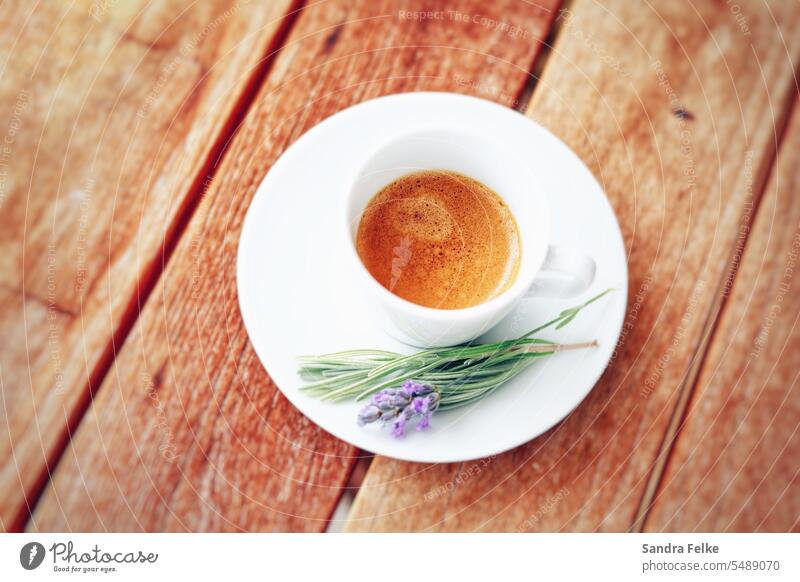 Eine weiße Espressotasse mit Espresso auf einem Holztisch. Auf der Untertasse liegt ein Lavendelzweig. holztisch Kaffee Farbfoto Tasse Getränk Kaffeepause
