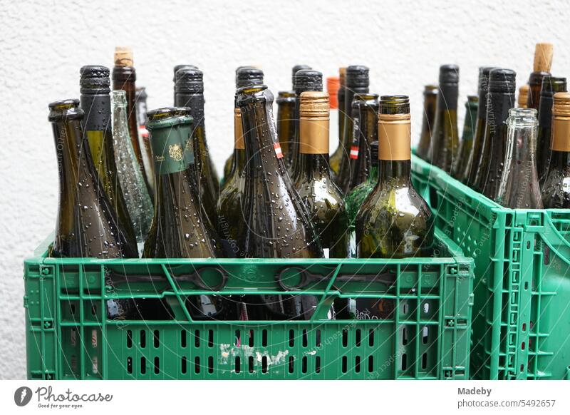 Klappkisten in Grün aus Kunststoff mit leeren Weinflaschen mit regentropfen im Hinterhof der Gastronomie in der Braubachstraße in der Innenstadt von Frankfurt am Main