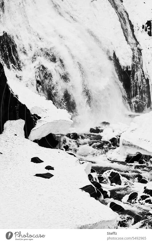 Wasserfallausschnitt mit Schnee, Felsen und vereistem Wasser auf Island Ostisland eisig kalt Wasserkaskade Kaskade Schneedecke schneebedeckt Frost Kälte Urkraft