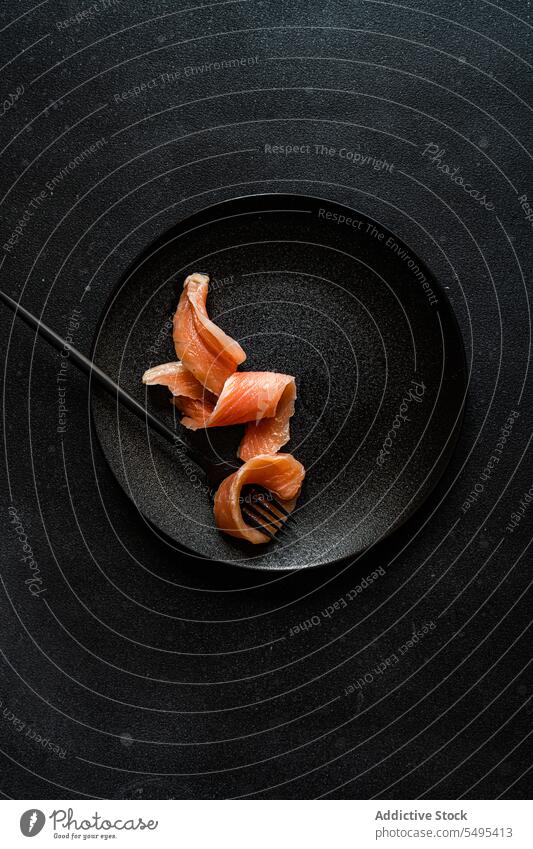 Gesunder Lachs in Scheiben auf dunklem Teller Speise Gesundheit Lebensmittel schwarz dunkel Vor dunklem Hintergrund Tisch Oberfläche lecker frisch Ernährung