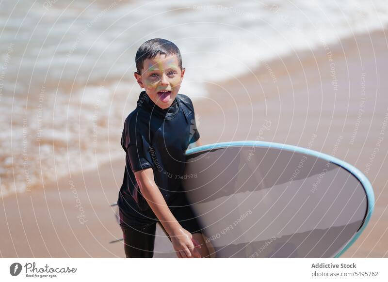 Fröhlicher Junge mit Surfbrett am Sandstrand Strand Sommer Spaziergang MEER führen Surfer Lächeln Kind Glück positiv Freude lustig Urlaub Aktivität Kindheit