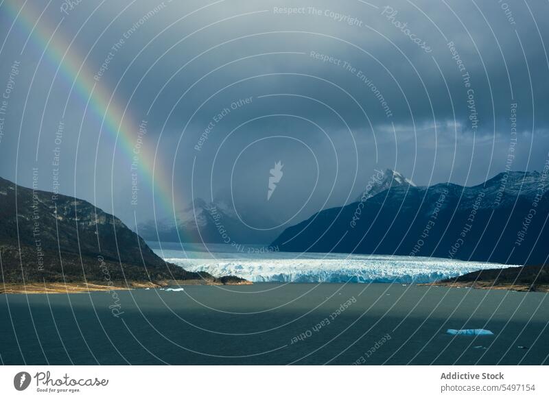 Blick auf einen eisigen See und Berge mit Regenbogenwolke Schnee wolkig Natur Himmel Berge u. Gebirge Hochland Winter Landschaft Kamm Wetter rau Air kalt