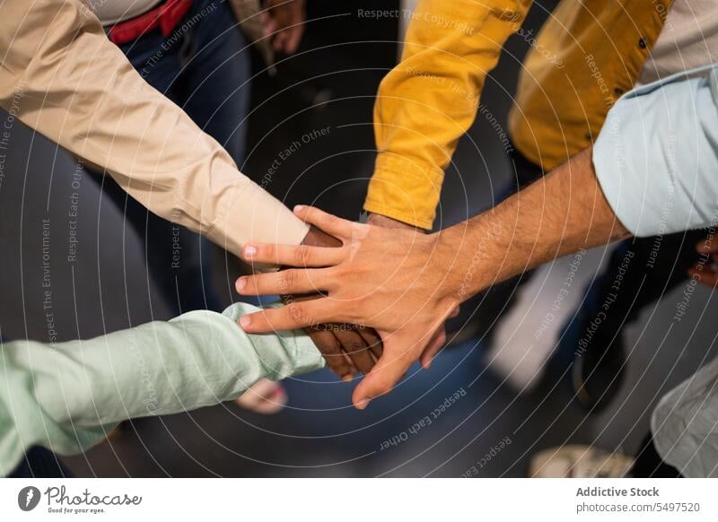 Unbekannte Teammitglieder, die zusammenstehen und sich im Licht die Hände reichen Hände stapeln kreisen Teamwork abstützen Menschengruppe kooperieren Einheit