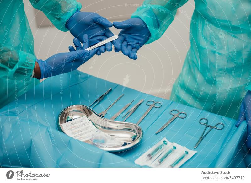 Assistent übergibt Instrument an Chirurg Arzt Praktikant arbeiten Werkzeug Latex Handschuh steril Chirurgie Operation Verfahren Operationssaal medizinisch