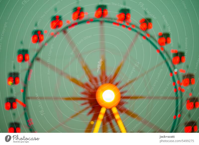 ein Riesenrad dreht sich in grün und rot Himmel Fahrgeschäfte Lichterscheinung kreisrund Design Strukturen & Formen Silhouette Experiment Unschärfe defokussiert