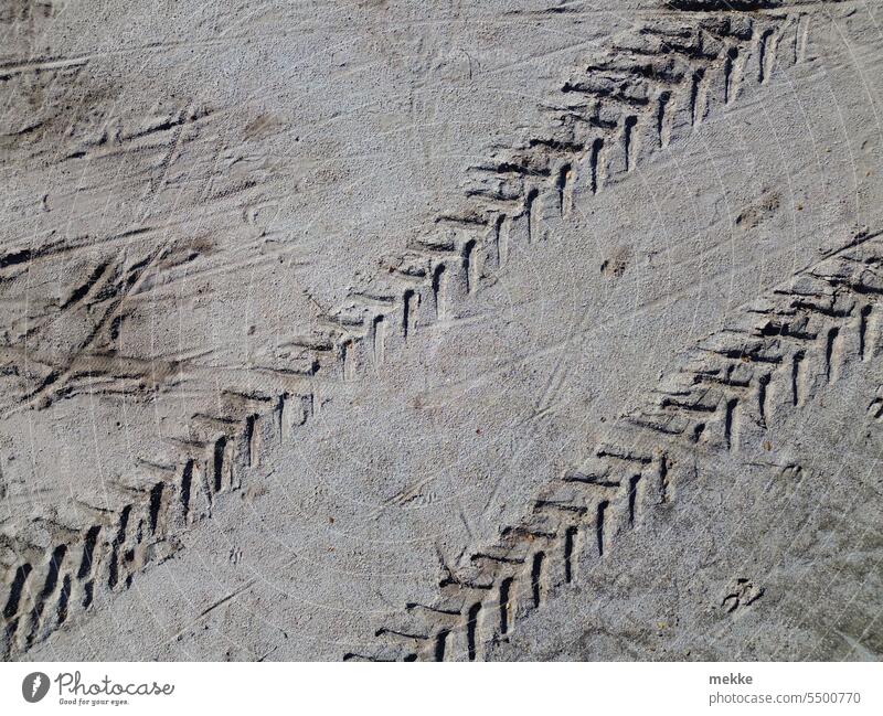 Spuren im Sand Strand Reifenspuren Boden Natur Profil Wüste Rillen Streifen durcheinander Sandstrand Abdruck Zerstörung Ebene Oberfläche Narben aufgewühlt hell