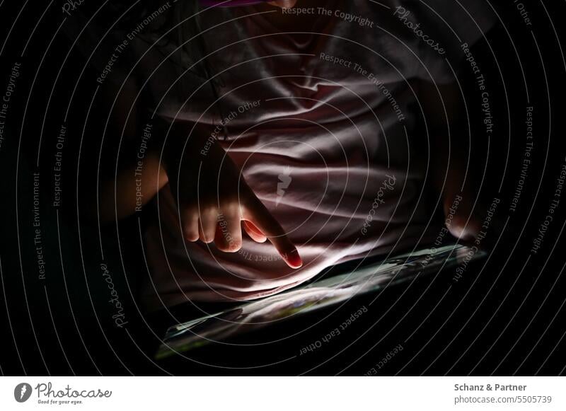Kind spielt im Dunkeln an einem Tablet und wird nur vom Screen angeleuchtet Chatten Medienpädagogik Social Media SMS Telefon Internet social media Handy