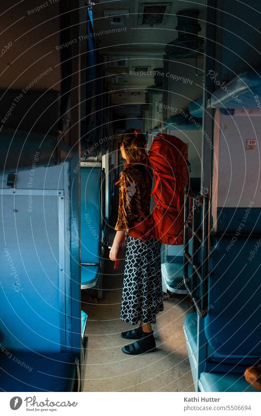eine Frau steht in einem indischen Schlafzug. Auf dem Rücken trägt sie einen roten Reiserucksack. reisen Zug Eisenbahn Verkehr Ferien & Urlaub & Reisen