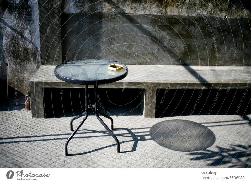 Runder Tisch mit Aschenbecher im Industriecafé am Morgen gelb keine Menschen rund kreisen Objekt im Freien Design Glas Metall Hintergrund Nahaufnahme Schatten