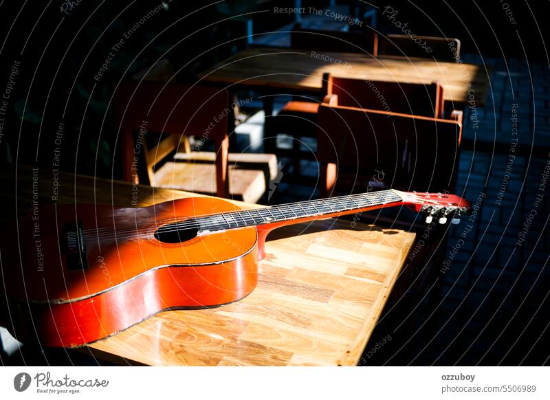 Akustikgitarre auf dem Tisch liegend im sonnigen Tag Musik Gitarre akustisch Instrument Schnur Holz Klang Hintergrund Objekt Melodie Musical Kunst braun hölzern