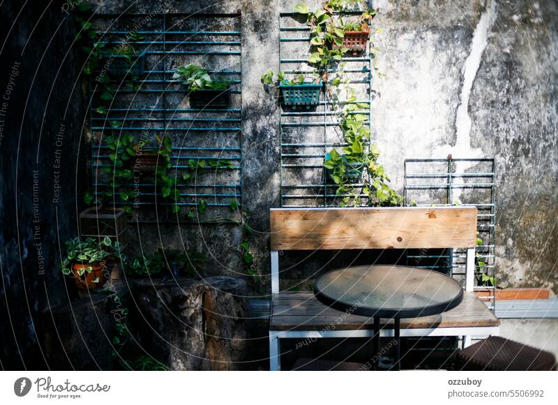 Runder schwarzer Tisch mit Holzstühlen im Garten am Morgen Stuhl im Freien Möbel Tag Design Natur sonnig leer grün außerhalb Dekoration & Verzierung Hintergrund