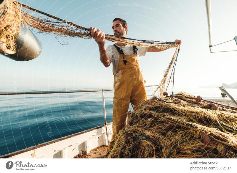 Fischer, der vom Segelboot aus im offenen Meer fischt Boot MEER Fischen Netz Schoner Arbeit Uniform männlich Soller Balearen Mallorca Wadenfisch jagen Trawler