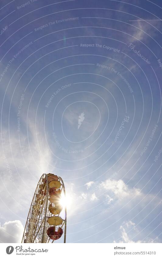 Die Sonne blitzt hinter einem Riesenrad hervor. Kirmes Rummel Volksfest Rummelplatz drehen Sonnenstrahlen Vergnügungspark Fahrgeschäfte Feste & Feiern Bewegung