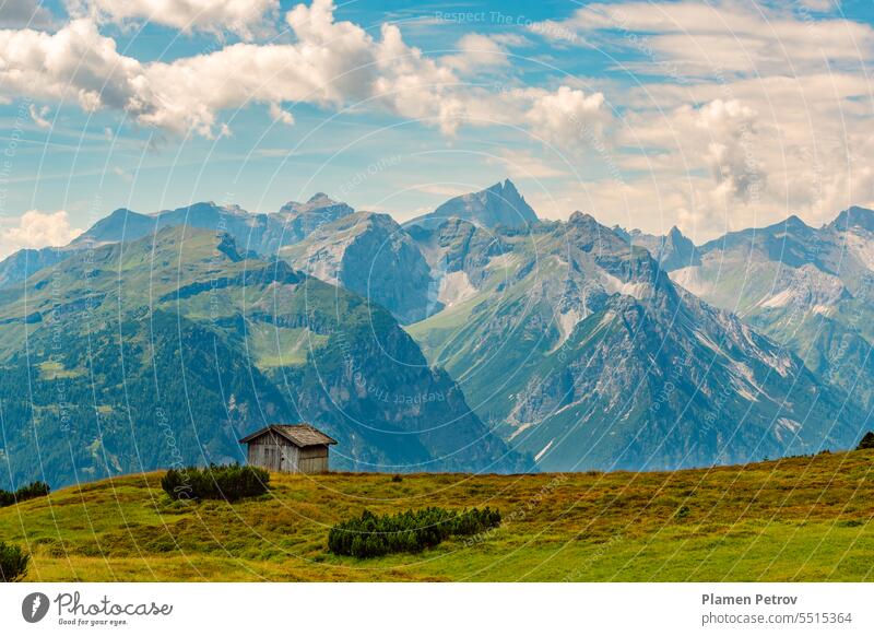Die malerischen Stubaier Alpen im Sommer, ein Panoramablick auf die Gipfel an der Grenze zwischen Österreich und Italien, ein hölzerner Heustadel auf einer grünen Wiese hoch über dem Gschnitztal, Tirol, Österreich.