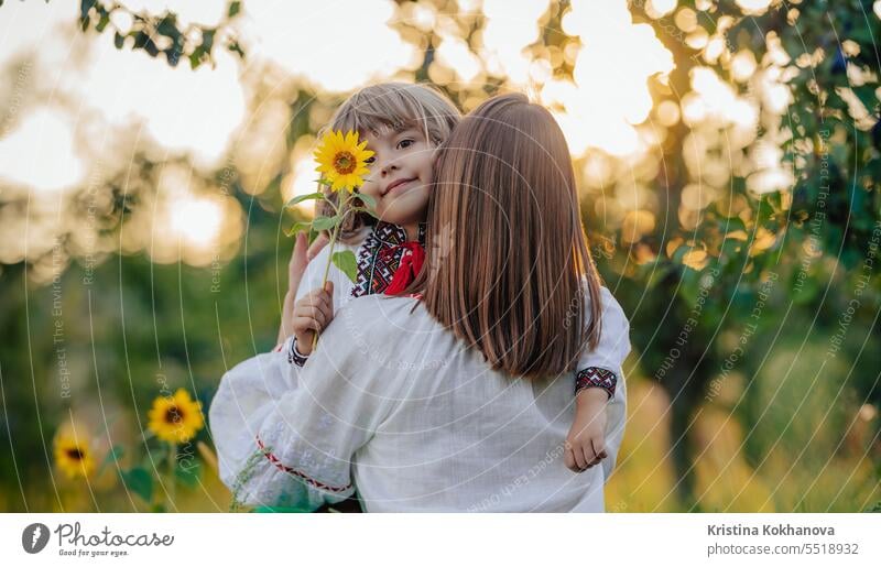 Portrait einer schönen Familie - 4 Jahre alter Junge mit Sonnenblume, Mutter im Garten Mama Ukrainer Sohn Glück Umarmung Liebe Eltern Pflege Fröhlichkeit