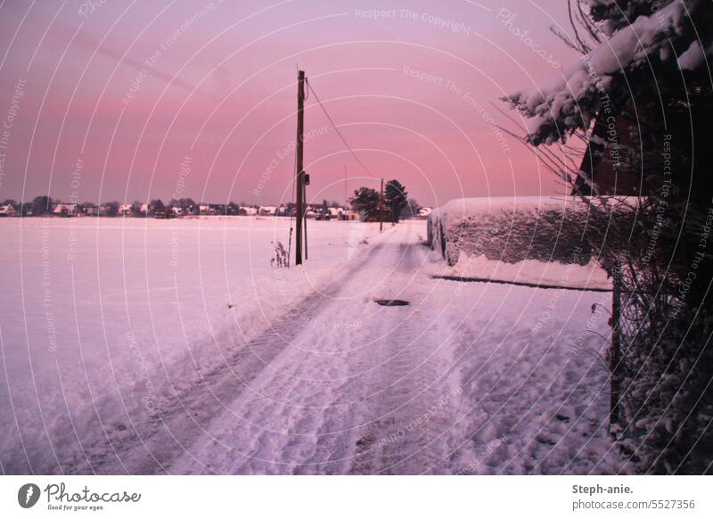 Winteridylle bei Sonnenuntergang feldweg Abend Schnee Schneelandschaft Roter Himmel Dorf Dorfidylle Landleben Landschaft Dämmerung kalt Menschenleer Frost