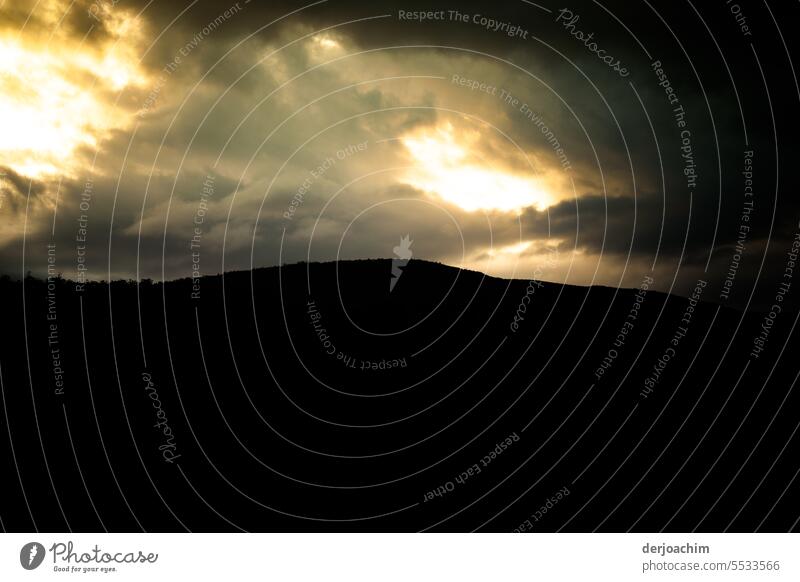 Dunkle Wolken über den Bergen mit etwas Sonnenlicht. dunkle Wolken ziehen auf Außenaufnahme Natur Himmel Menschenleer Wetter Umwelt Unwetter dunkel