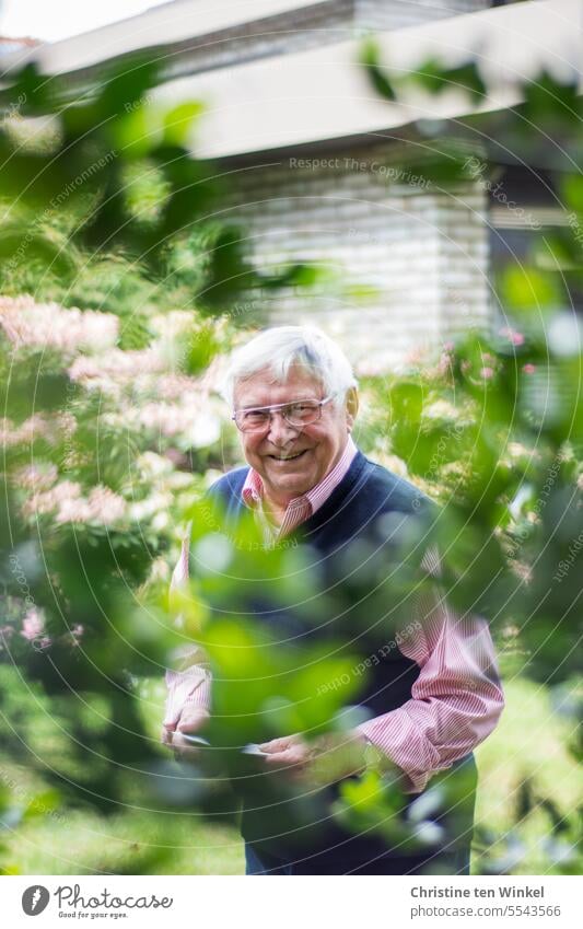 Lieblingsfrisur | kurze weiße Haare Senior Mann älterer Mann Rentner lächeln Brille Brillenträger gut gelaunt Hemd Opa Pullunder Garten Zweige Haus Gesicht