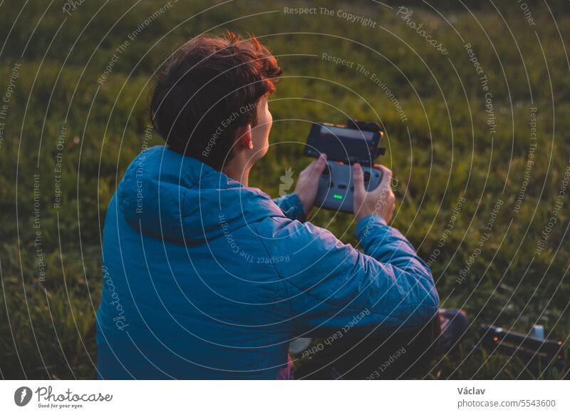 Ein junger Kameramann dreht Teile eines Films mit einer Drohne, einem technischen Gerät. Aufnahme des Sonnenuntergangs aus der Vogelperspektive Benutzer
