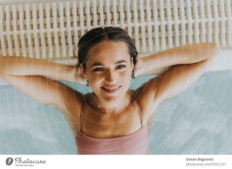 Junge Frau entspannt sich im Hallenschwimmbad Erwachsener allein attraktiv schön Schönheit Bikini Körper Kaukasier Tag genießen genießend frisch Glück Halt