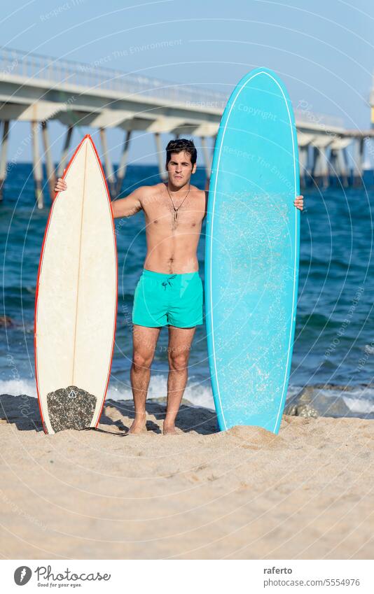 Junger gut aussehender Mann mit Surfbrett am Strand Sommer Brandung Surfen männlich Sport Meer Holzplatte Freizeit Wasser im Freien MEER Sand Surfer Lifestyle