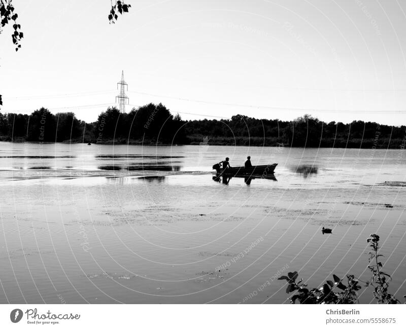 Schwarz-weiß-Foto kleines Boot mit 2 Menschen auf einem Fluss Bootsfahrt Schifffahrt Wasser Ferien & Urlaub & Reisen Außenaufnahme Tourismus Wasserfahrzeug