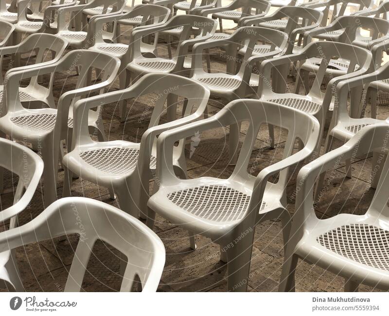 Leere Reihen weißer Plastiksitze oder Stühle bei einer Konzertveranstaltung im Freien oder in einem Freilufttheater. Kein Publikum im Kino im Freien. Stuhl Film