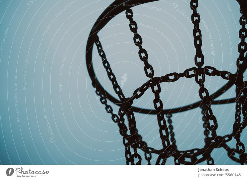 Basketballkorb aus Metall Silhouette vor Himmel Stahl Ketten Eisenkette schwarz düster Sport Freizeit Strand blau Ballsport Basketballplatz basketballnetz