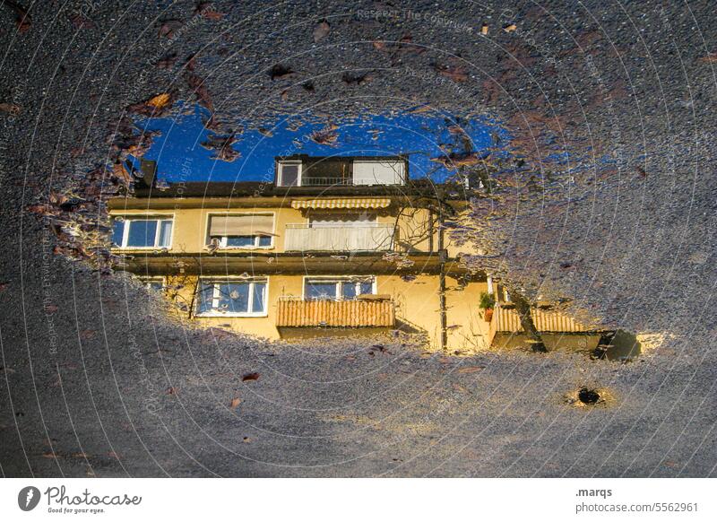 Mehrfamilienhaus in Pfütze Reflexion & Spiegelung nass Haus optische täuschung Wohnhaus Perspektive wohnen grau Wasser Fenster Balkon Gebäude Wolkenloser Himmel