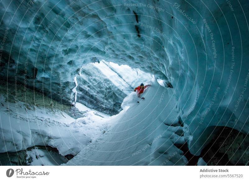 Skifahrer mit Skistöcken bei der Erkundung einer Höhle im Urlaub unkenntlich Skifahren Berghang Mast verschneite Berge u. Gebirge erkundend Schnee aktiv Natur