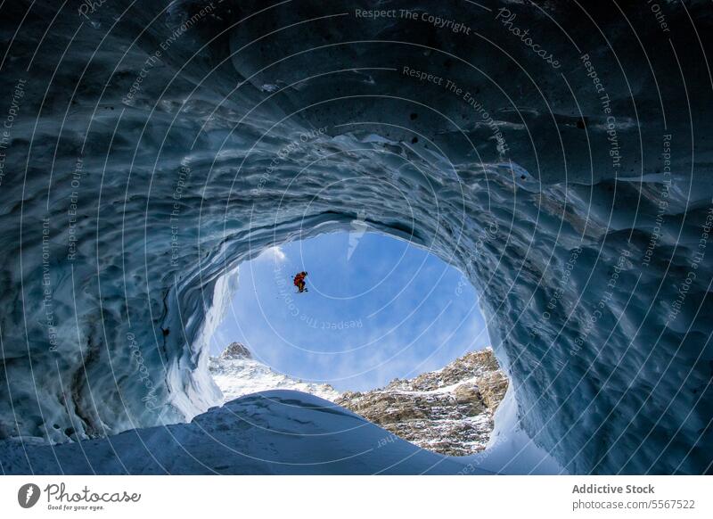 Person beim Skifahren auf einem verschneiten Berg durch eine Höhle gesehen Berge u. Gebirge Winter Tag Urlaub Ganzkörper Schnee Abenteuer Skifahrer bergab