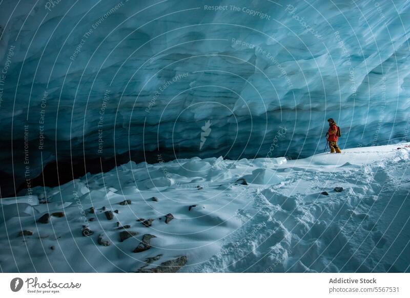 Skifahrer mit Skistöcken erkundet Höhle auf Schneeberg unkenntlich Mast laufen verschneite Berge u. Gebirge erkundend Urlaub Erkundung Person wandern Winter